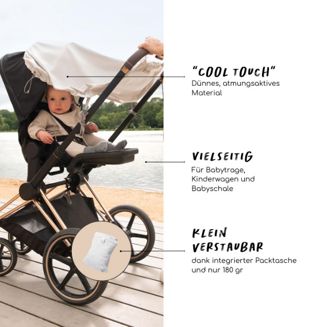 Ein Baby in einem Kinderwagen, der ein weißes Sonnen-Cover übergespannt hat.